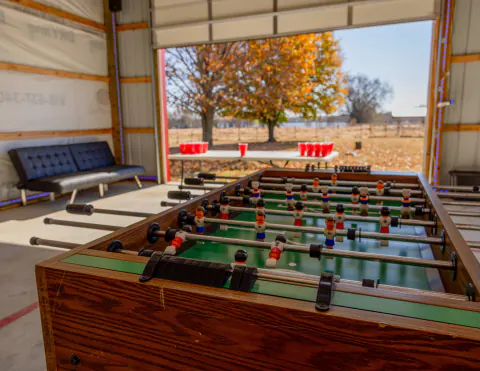 Foosball table in the game room, with the door open to autumn trees