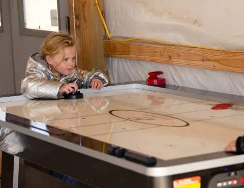 Little girl playing air hockey