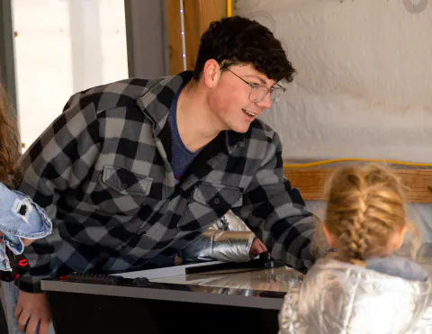 Young man playing air hockey with a child