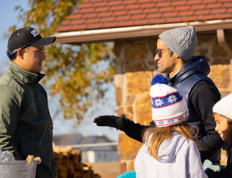 Guests talking outside a stone building at Lake Hudson Resort on an autumn day