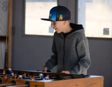 Boy playing foosball in the game room