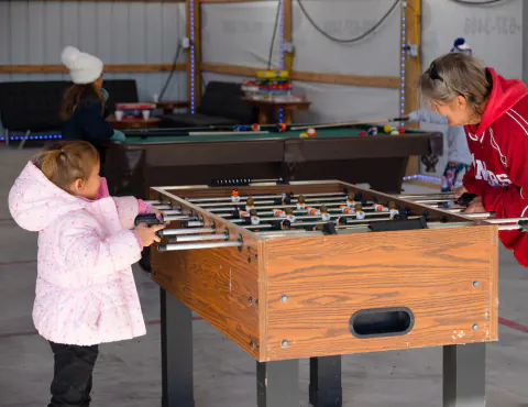 Family playing foosball next to the billiards table