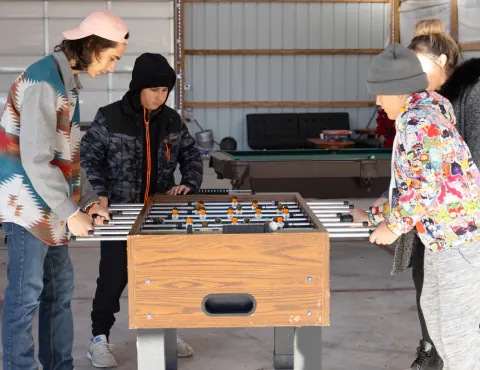 Teens playing foosball in the game room