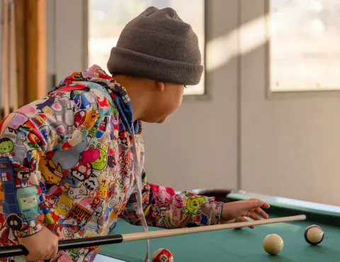 Boy lining up a billiards shot