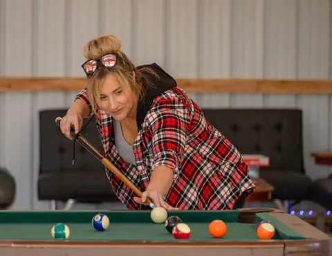 Woman lining up a shot at the billiards table