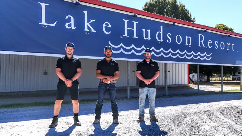 Lake Hudson Resort team members in front of the Lake Hudson Resort sign